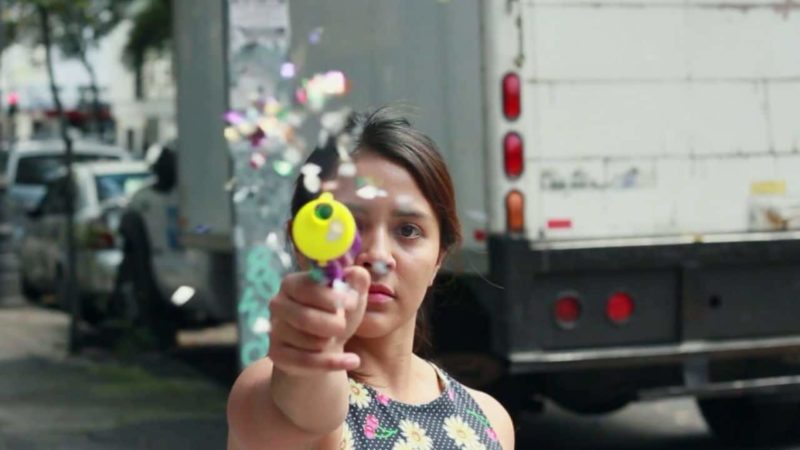 Une femme tire avec un pistolet à confettis