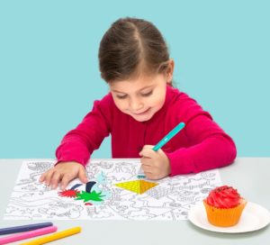 Une petite fille colorie son set de table.